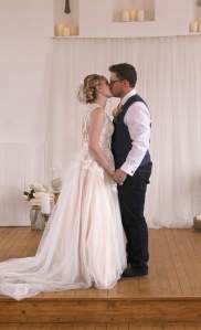 Melissa and James at their wedding kissing at the alter. 